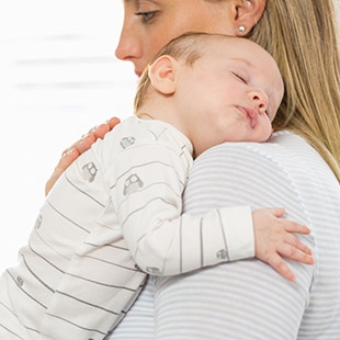 Imagen madre con bebé en brazos dormido - salud bebé