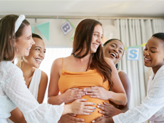 mujeres tocando la barriga de otra mujer