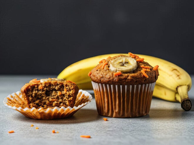 Banana muffin with sliced banana on top, next to peeled muffin and bananas.
