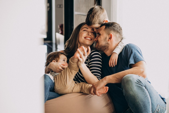 Familia feliz abrazándose en casa, representando amor y unión - Nestlé Bebé